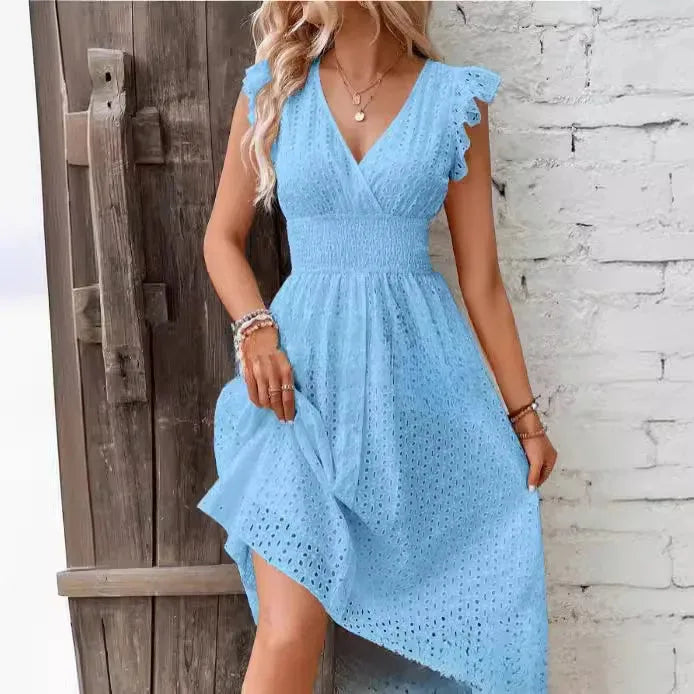 Close-up front view of a light blue eyelet midi dress showing the smocked waist and wrap neckline