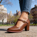Close-up front view of brown leather brogue T-bar heel with scalloped toe cap detailing