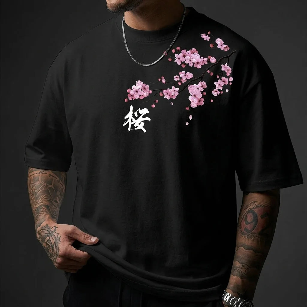 Close-up detail of black tee fabric showing the pink cherry blossom print, white kanji character and crew collar stitching