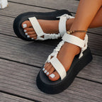 Detail shot of gold and orange metallic straps crossing over the foot on a platform sandal