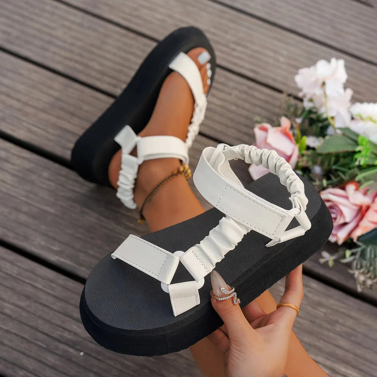 Top-down view of metallic multicolour platform sandals paired with layered gold anklets