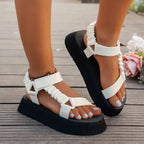 Close-up of metallic blue, gold, orange and pink straps on a platform sandal worn outdoors