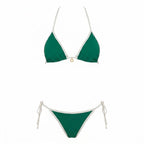 Front view of model wearing navy triangle bikini top with thin adjustable straps and cream trim