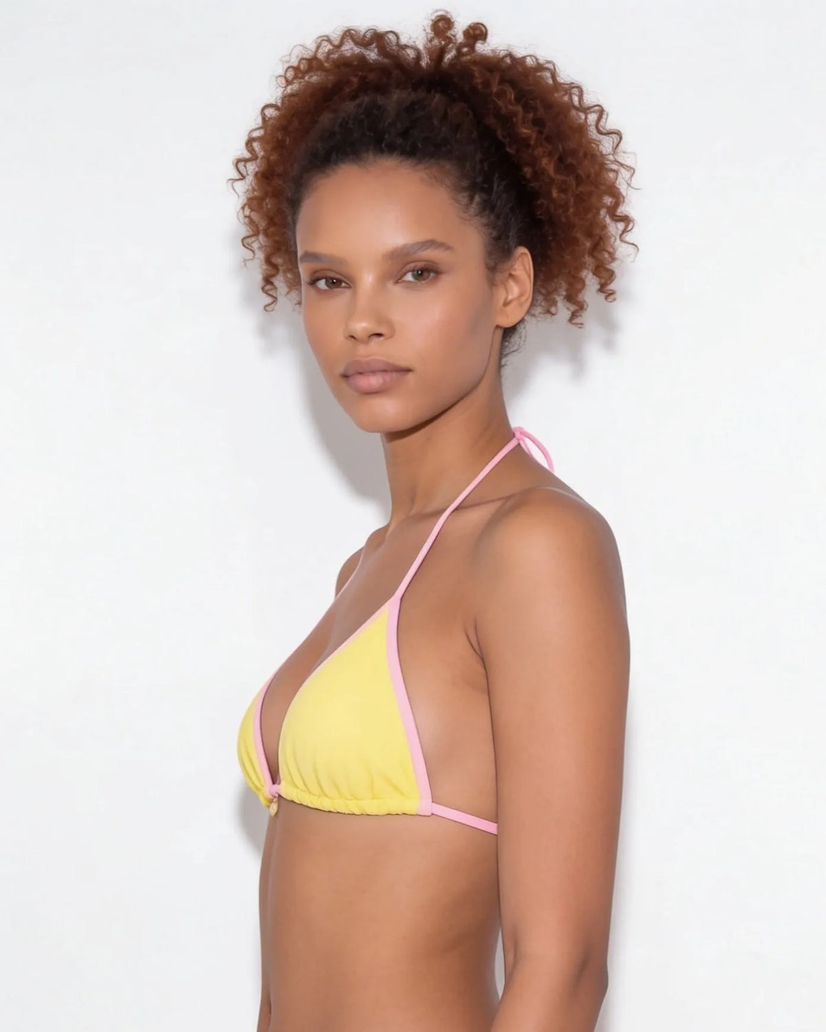 Side view of model in brown triangle bikini showing the high-cut bottom silhouette