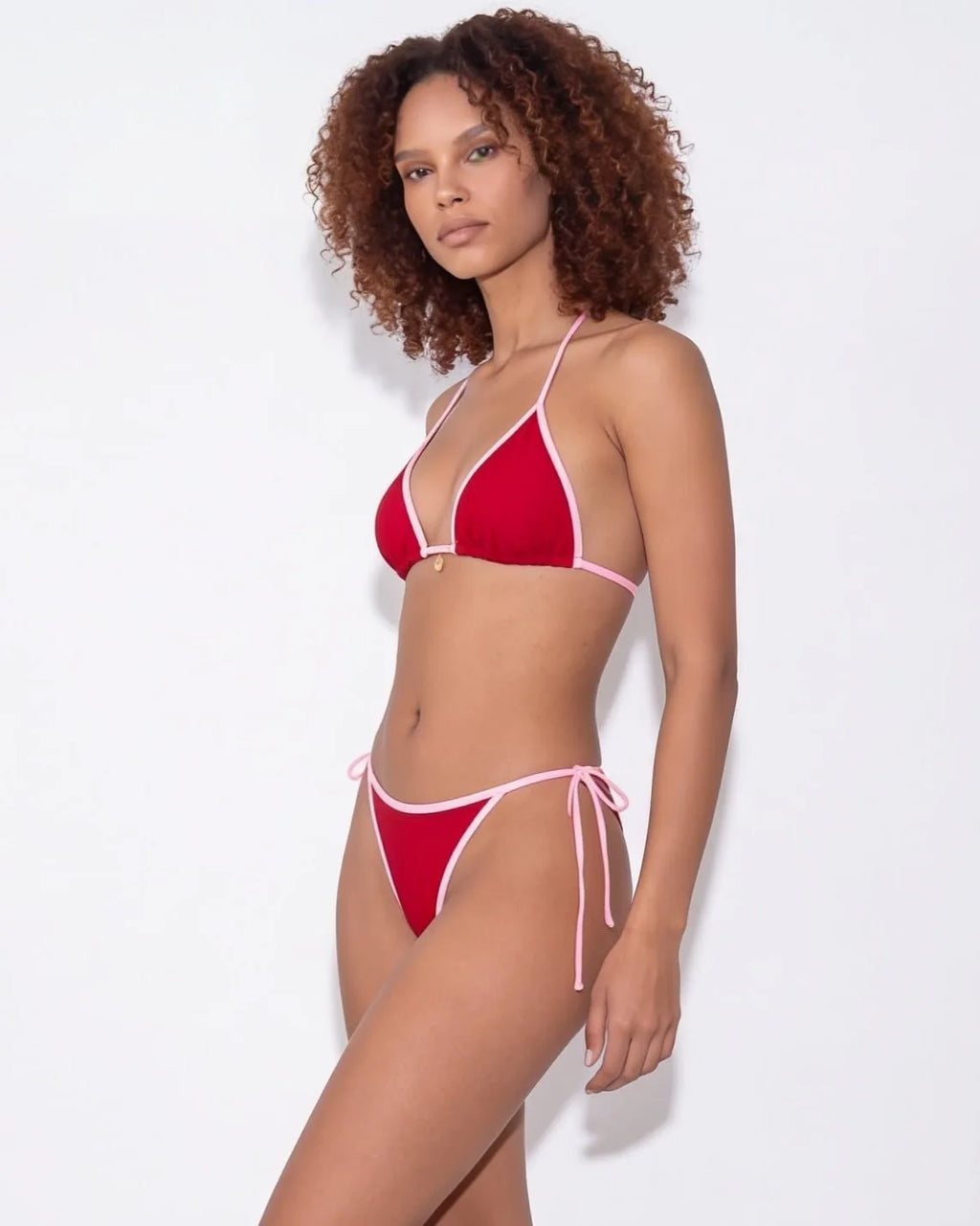 Front view of model in navy bikini with hands by her sides against white background