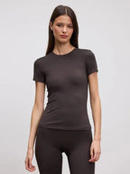 Close-up front view of a fitted dark brown crew neck tee paired with matching brown leggings