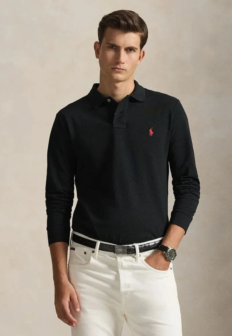 Man wearing a black long-sleeve polo shirt styled with white denim jeans and a leather belt