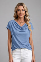 Woman wearing the light blue cowl neck top showing the soft drape across the front torso