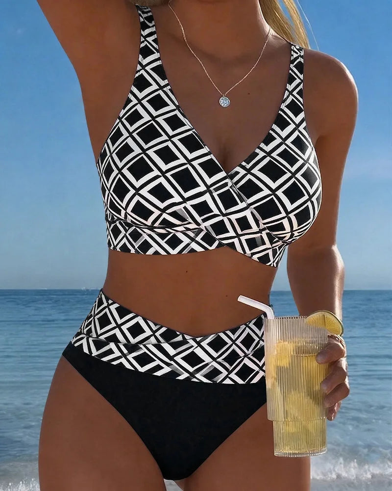 Front view of a black and white geometric print wrap bikini set with high-waisted bottoms against the ocean