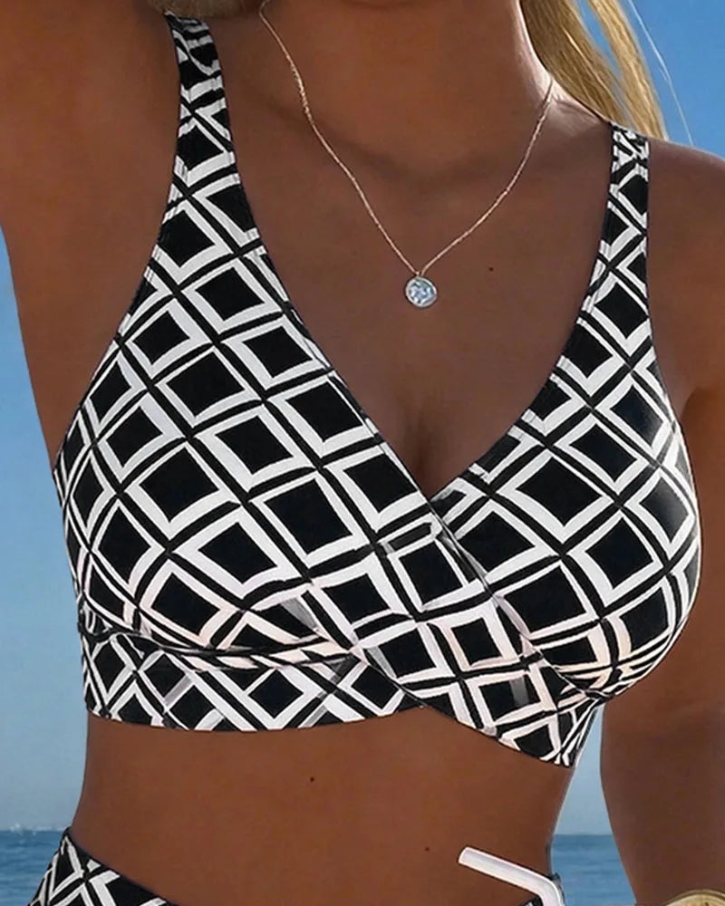 Close-up of the black and white diamond print wrap top showing the crossover V-neckline and wide shoulder straps