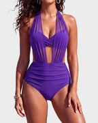 Beach portrait of a smiling woman wearing the grey-blue striped mesh swimsuit with gold jewellery