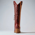Front view of a brown leather cowboy boot showing the pointed toe and intricate stitched pattern