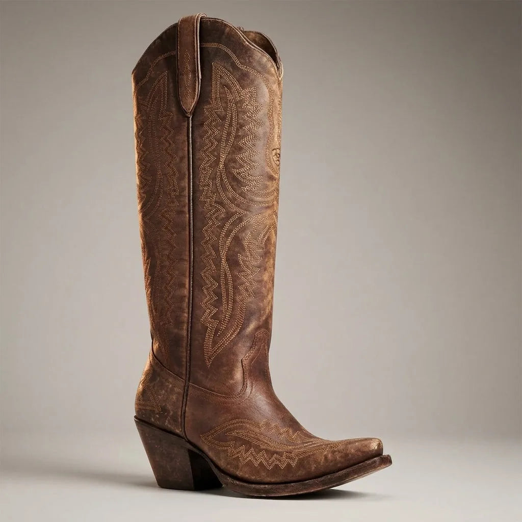 Side profile of a distressed chocolate brown leather cowboy boot with contrast stitching and pointed toe