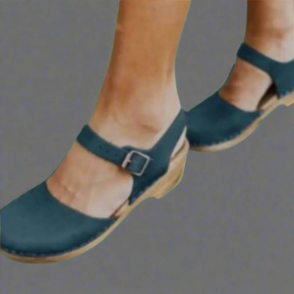 Close-up of teal nubuck clog sandals with mary-jane buckle strap and wooden platform sole