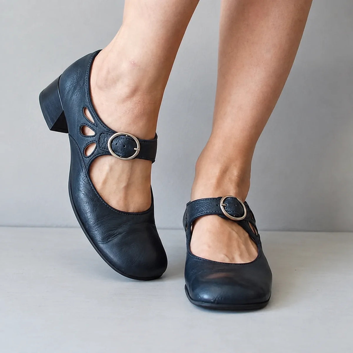 Navy leather mary jane flats with teardrop vent cutouts, silver buckle strap and low block heel