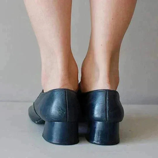 Back view of navy leather mary jane flats highlighting the curved low block heel and seam detailing