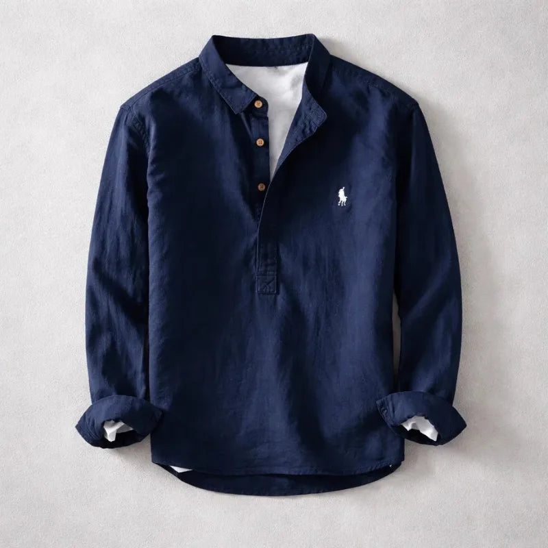 Navy linen-blend henley shirt with band collar, buttoned placket and rolled cuffs, laid flat on a grey background