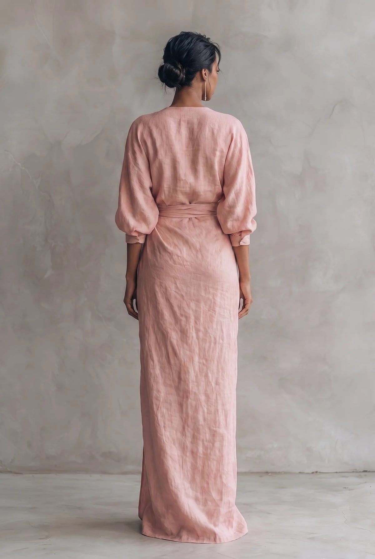 Back view of the pink maxi dress highlighting the tie-waist belt and relaxed V-back neckline