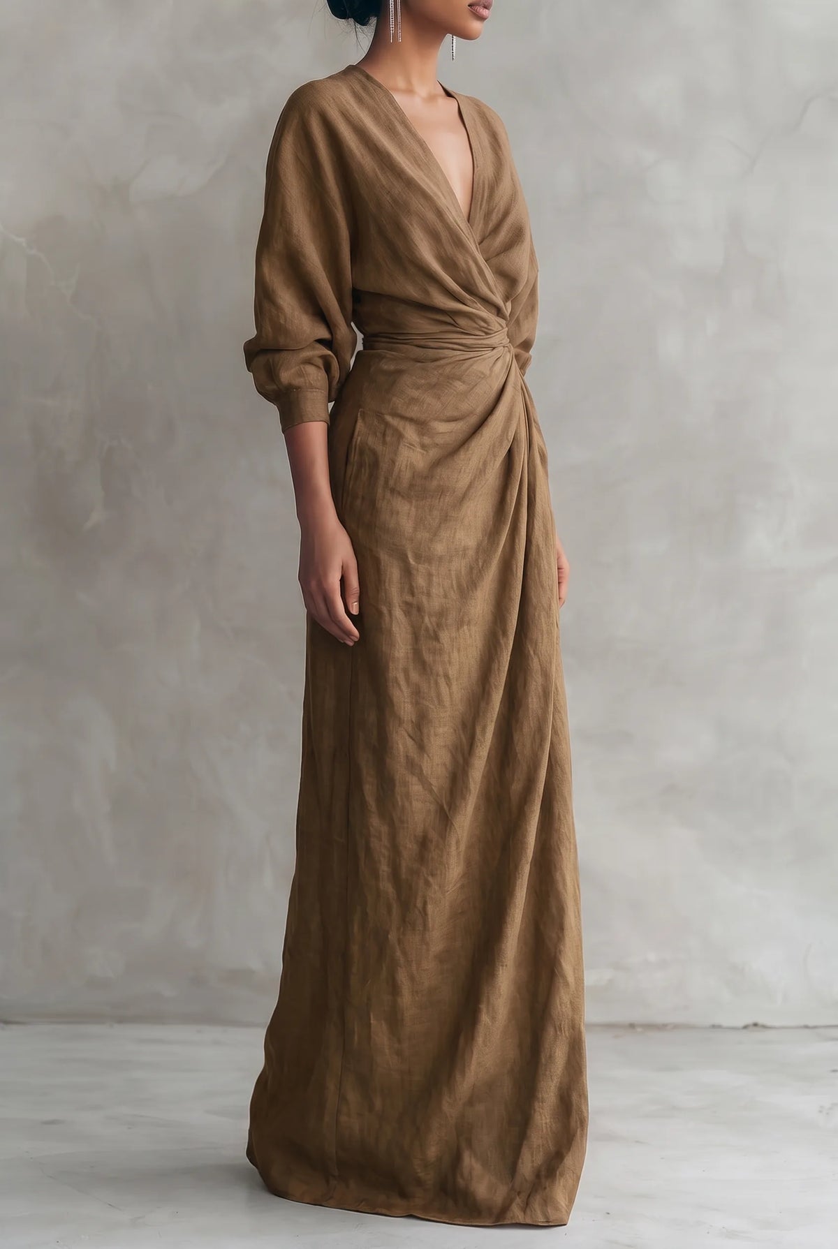 Side profile of the brown linen-blend dress showing the cinched waist drape and three-quarter sleeve volume