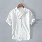 White short-sleeve linen-cotton shirt with stand collar and button placket, hanging flat against a plain grey backdrop