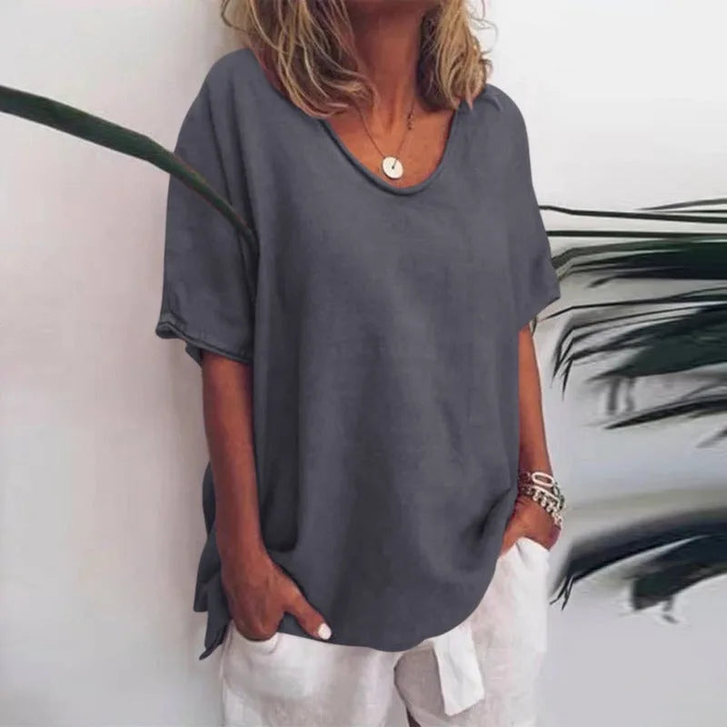 Close-up front view of a woman wearing a dark grey oversized linen-look t-shirt with a round neckline and dropped shoulders