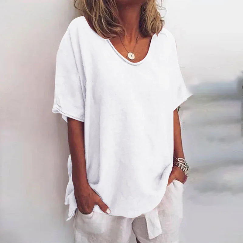Woman modelling the oversized tee in white, with rolled short sleeves and a soft round neckline