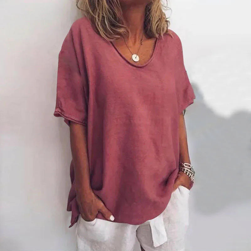 Front view of the relaxed t-shirt in dusty rose pink, paired with white linen-style pants