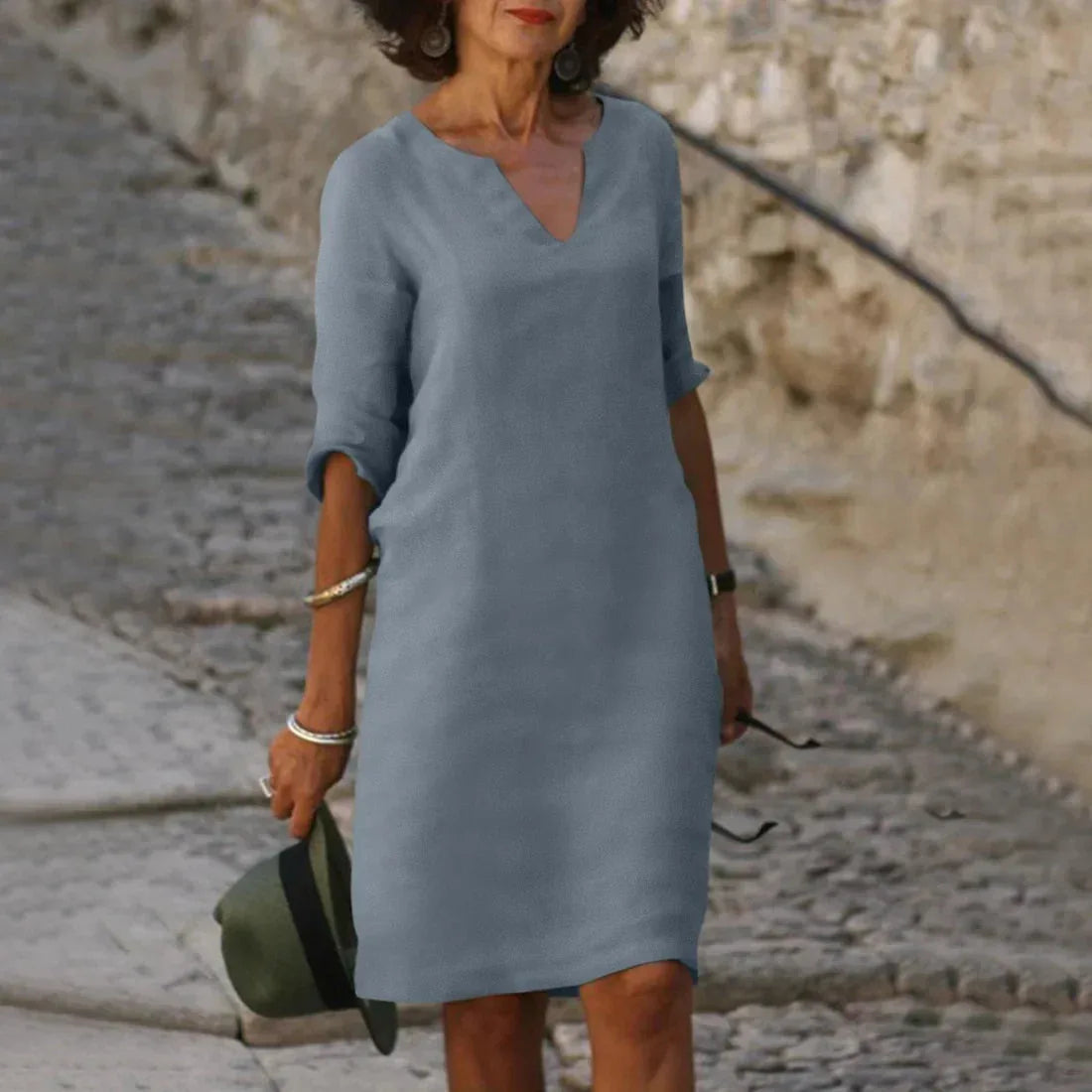 Soft blue-grey V-neck dress with three-quarter sleeves and straight hemline above the knee