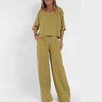 Woman wearing the two-piece set in mustard yellow, boxy cropped top and wide leg pants with pockets