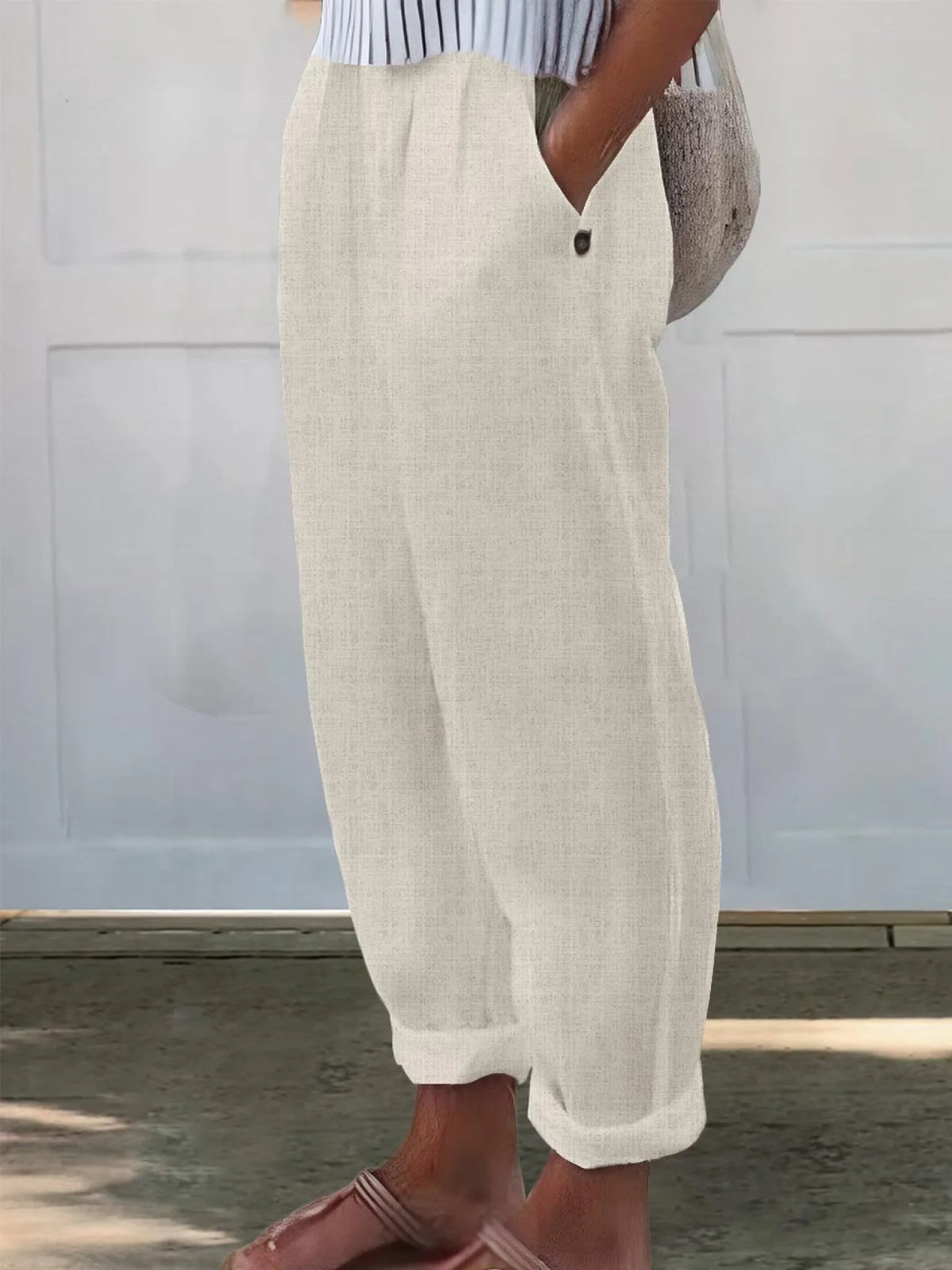 Side view of cream/off-white wide-leg pants showing textured woven fabric and relaxed tapered cuff