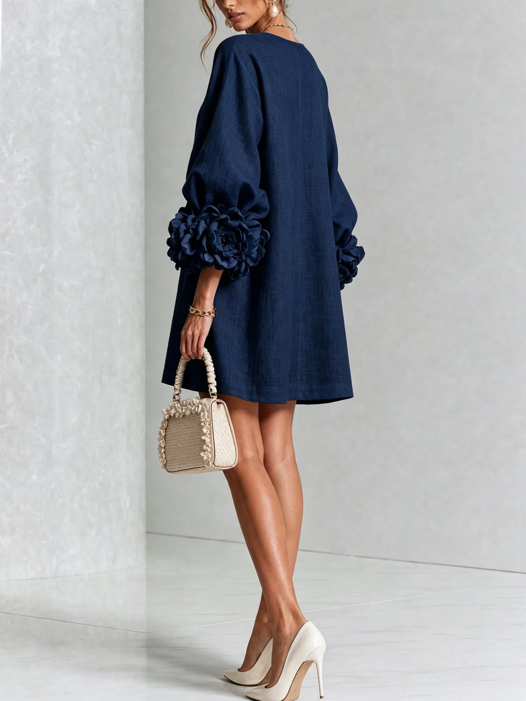 Back three-quarter view of the white textured dress showing the smooth back panel and sleeve volume