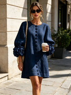Close-up of hands holding a woven handbag while wearing the white textured mini dress with floral cuff