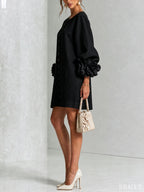 Front view of the white mini dress styled with white pointed-toe heels and a quilted floral handbag