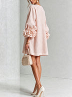 Close-up of the vertical row of floral buttons from neckline to hem on the white textured dress