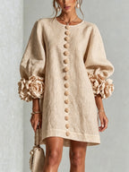 Front view of the olive mini dress showing the floral cuffs and button placket against a neutral backdrop