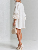 Back view of the white mini dress showing the relaxed shift silhouette and voluminous sleeve shape