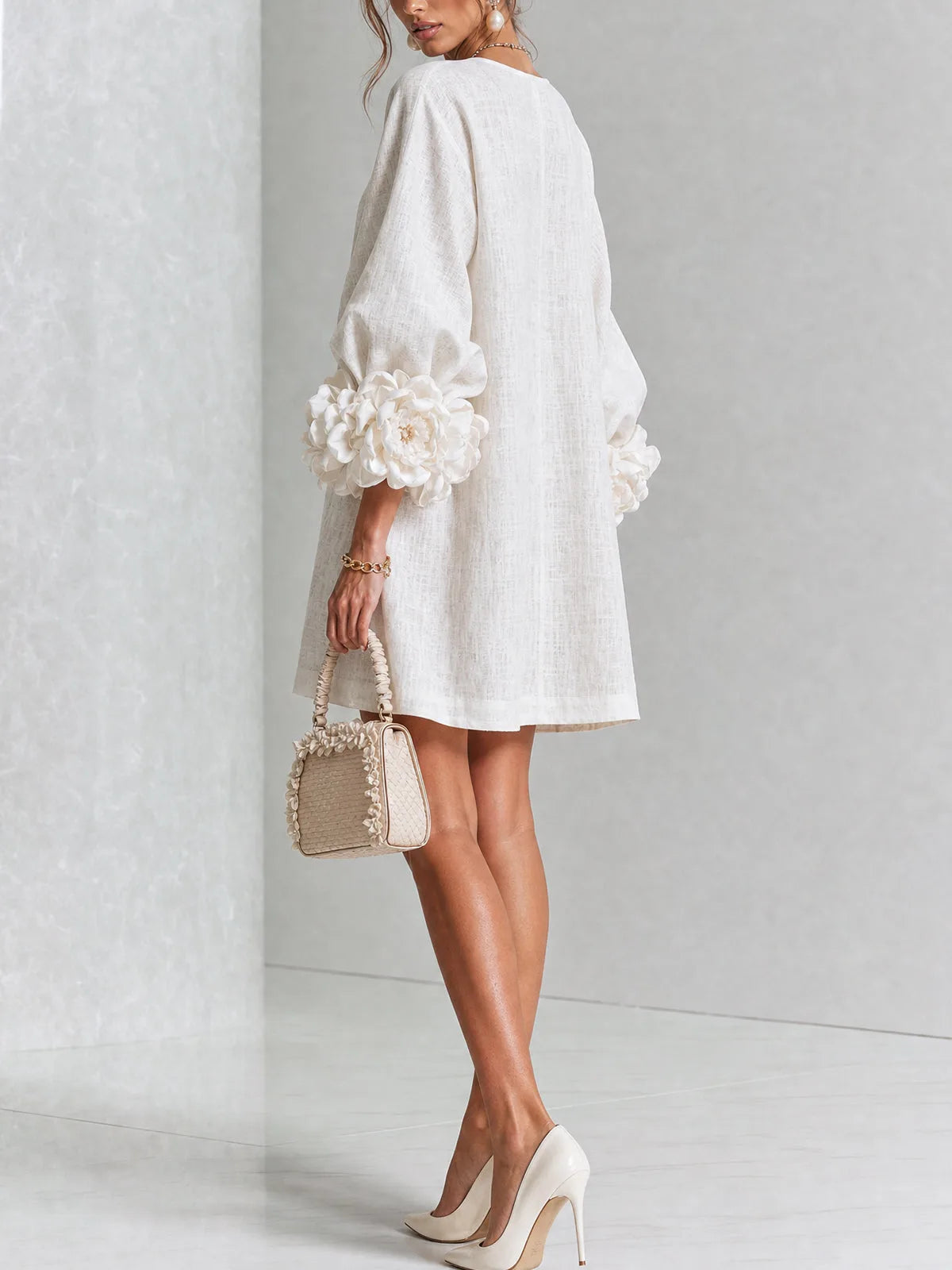 Back view of the white mini dress showing the relaxed shift silhouette and voluminous sleeve shape