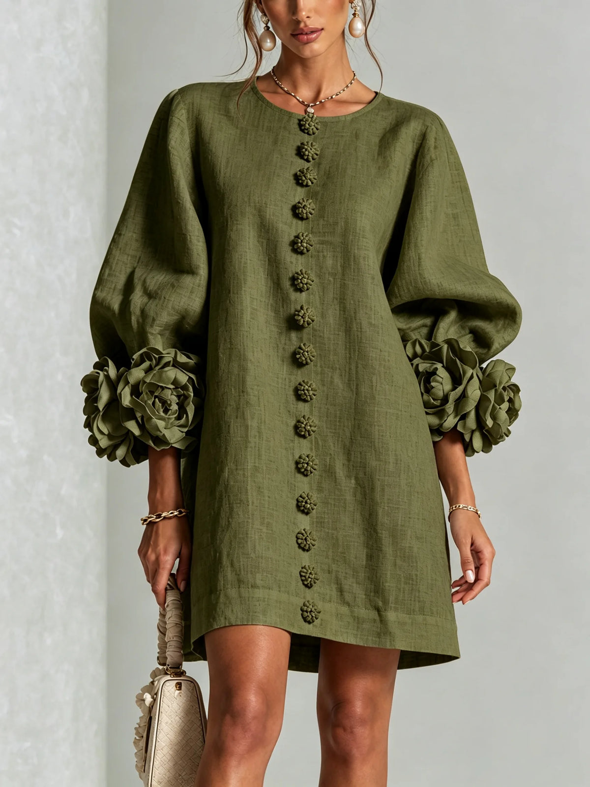 Front view of the olive green textured mini dress with voluminous floral cuffs and matching button trim