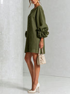 Side view of the olive green shift dress showing the puff sleeve volume and floral cuff detail