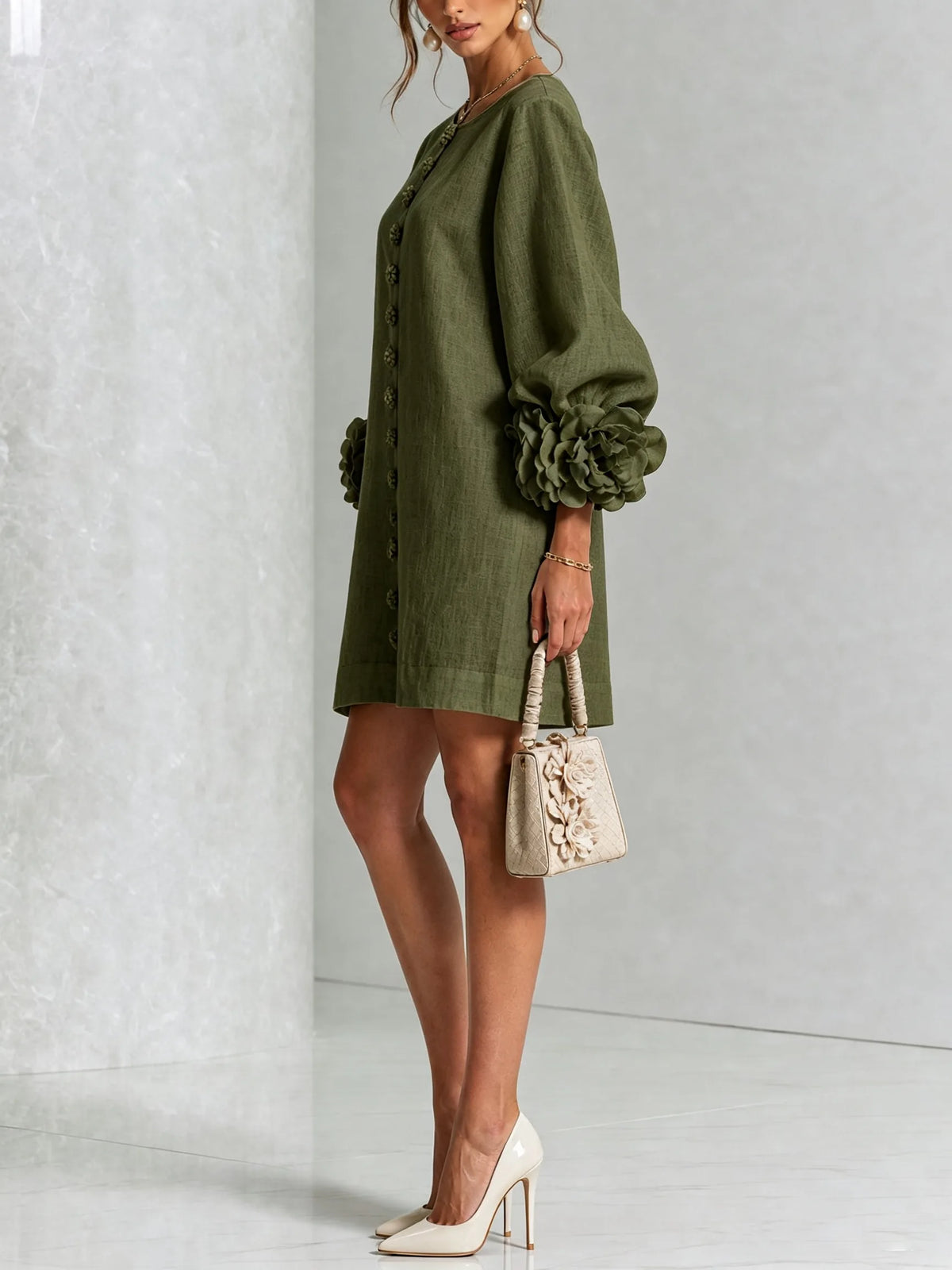 Side view of the olive green shift dress showing the puff sleeve volume and floral cuff detail
