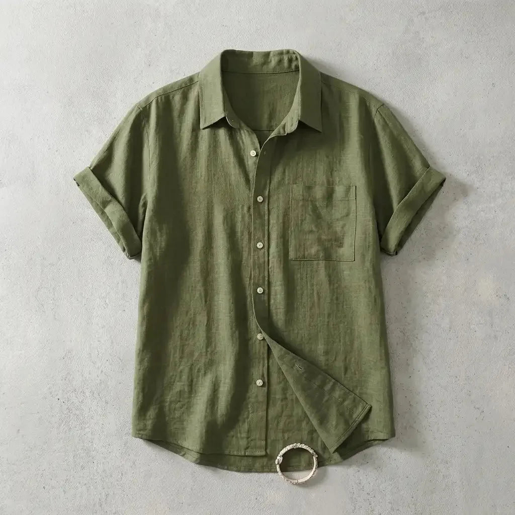 Olive green linen short-sleeve shirt with chest pocket, shown flat with sleeve folded open to reveal hem detail