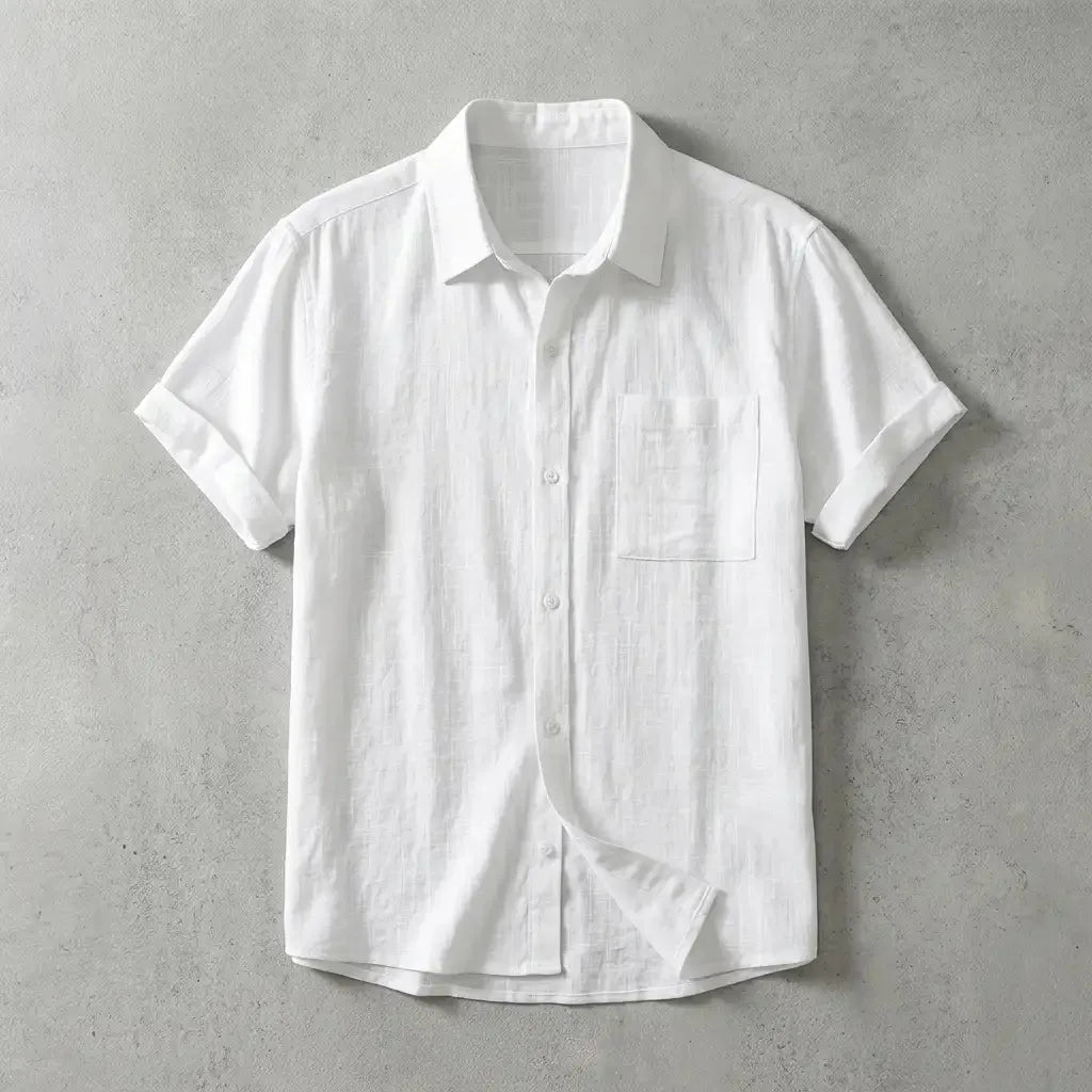 White linen short-sleeve shirt with chest pocket and rolled sleeves, laid flat with one cuff folded back