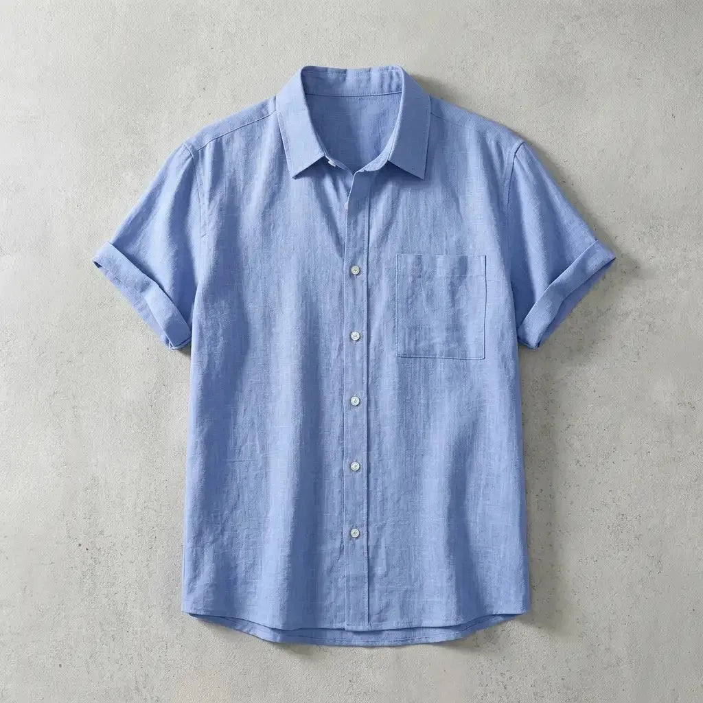 Light blue linen short-sleeve shirt with chest pocket, laid flat showing relaxed collar and button placket