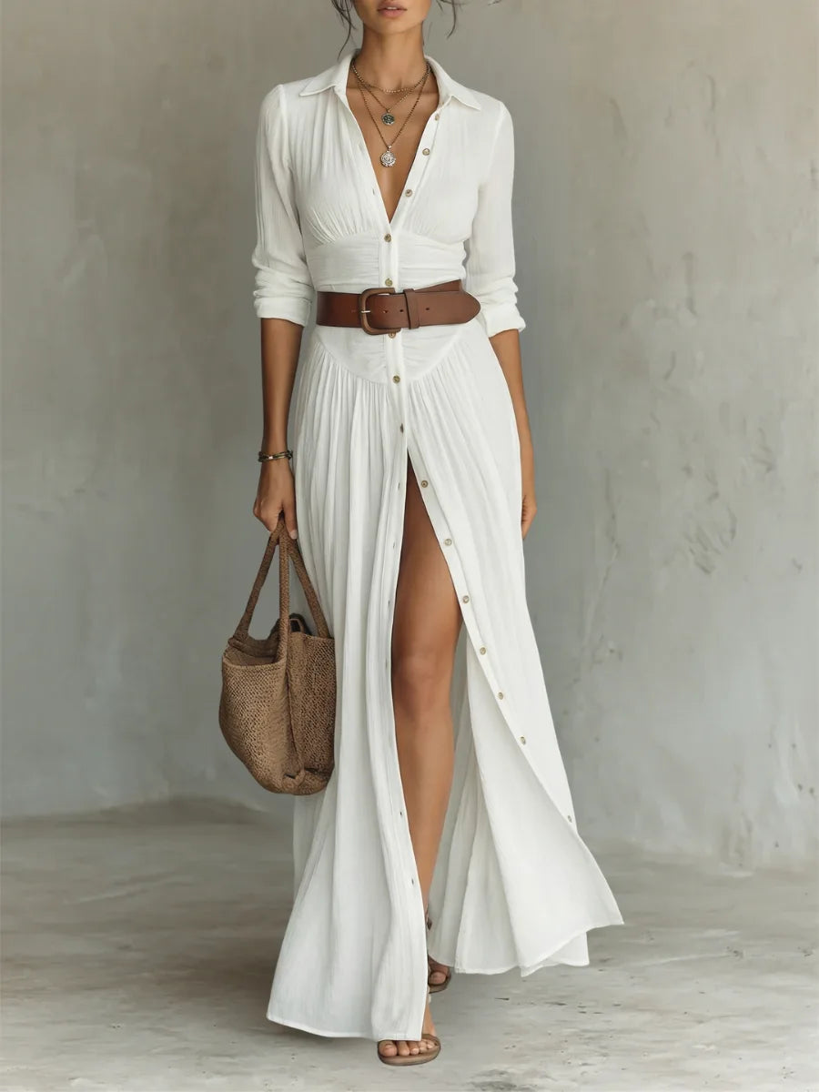 Woman modelling a white button-front maxi dress with notched collar, cinched with a brown leather belt and thigh-high slit