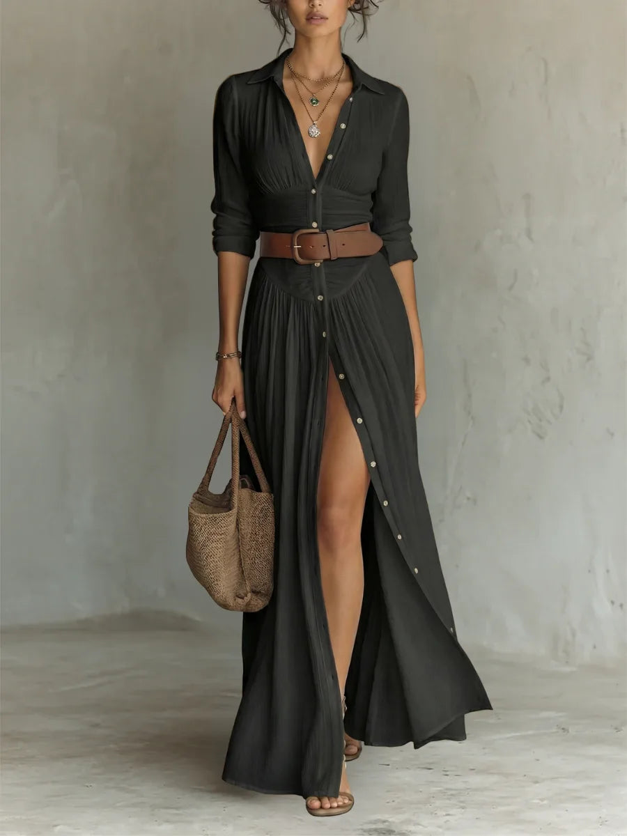 Black button-front maxi dress with notched collar, long sleeves and brown belt, shown with a woven tote and sandals