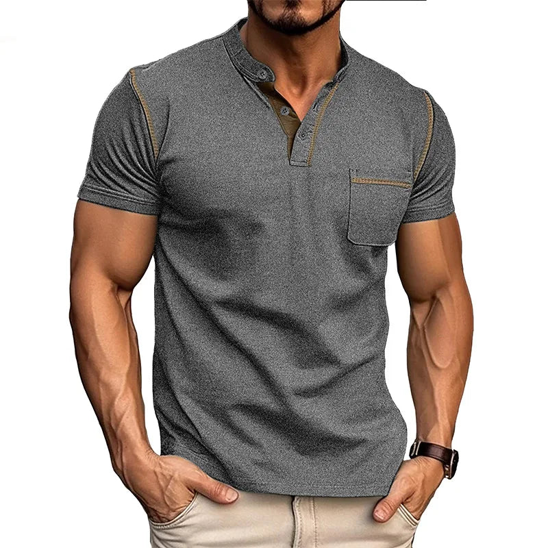 Front view in dark grey showing the fitted silhouette, chest pocket with contrast stitching and short sleeves