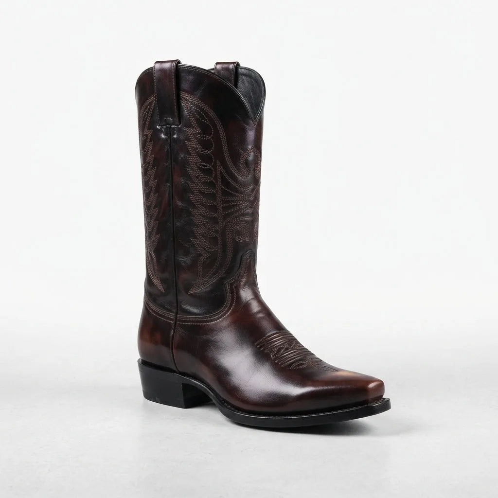 Angled view of the brown leather cowboy boot showing the pointed toe, pull tab and western stitch pattern