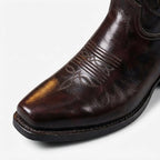 Close-up of the brown leather boot's square toe and stitched vamp, highlighting the polished leather grain