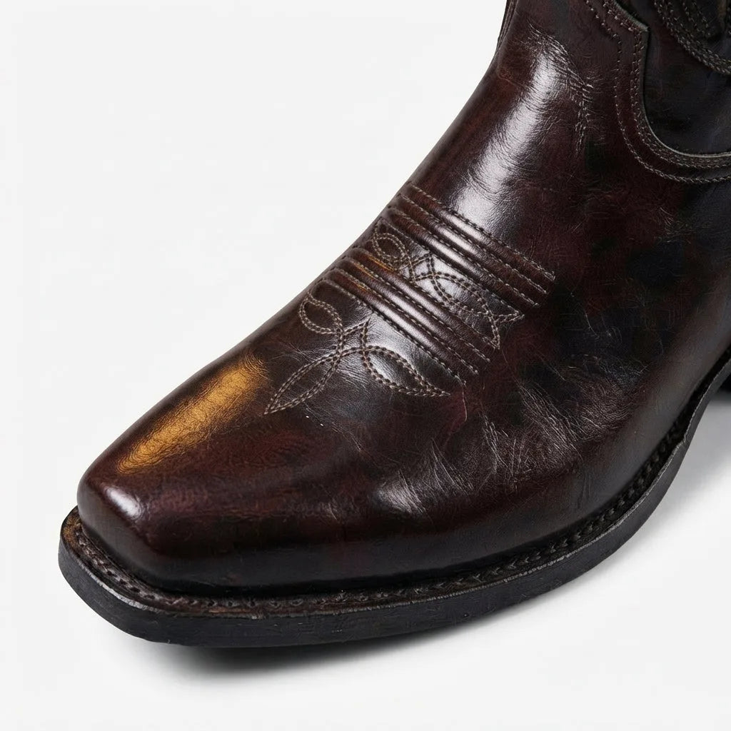 Close-up of the brown leather boot's square toe and stitched vamp, highlighting the polished leather grain