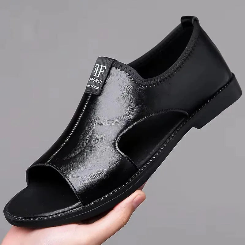 Black leather sandal with peg-toe cutout design and stitched trim, held up to show side profile.